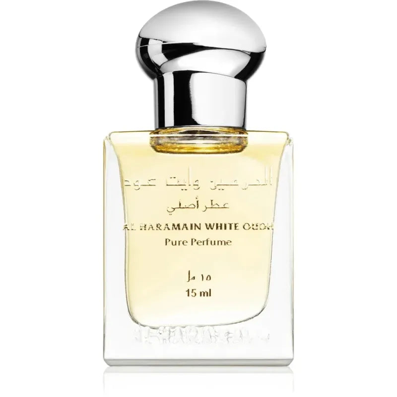 Een glanzende transparante glazen fles al haramain white oud pure parfumolie met zilveren dop en goudgele vloeistof