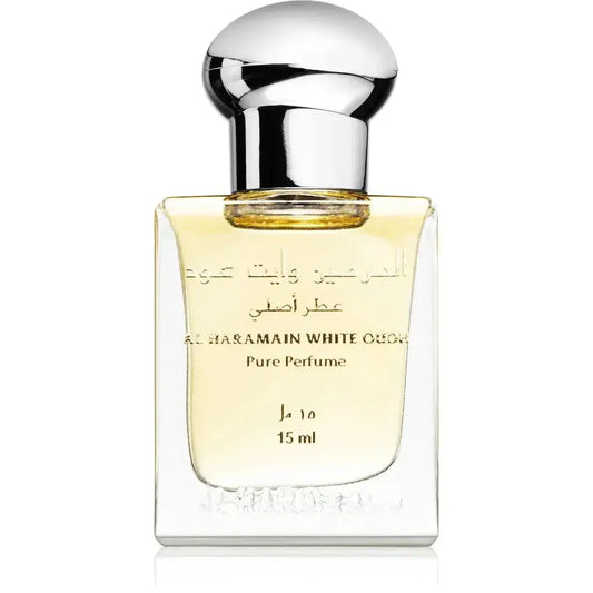 Een glanzende transparante glazen fles al haramain white oud pure parfumolie met zilveren dop en goudgele vloeistof