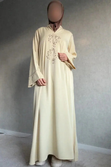 Een vloeiende, bleekgele kaftan abaya mayar dames met fijne goudkleurige borduursels op de borst en uitlopende mouwen