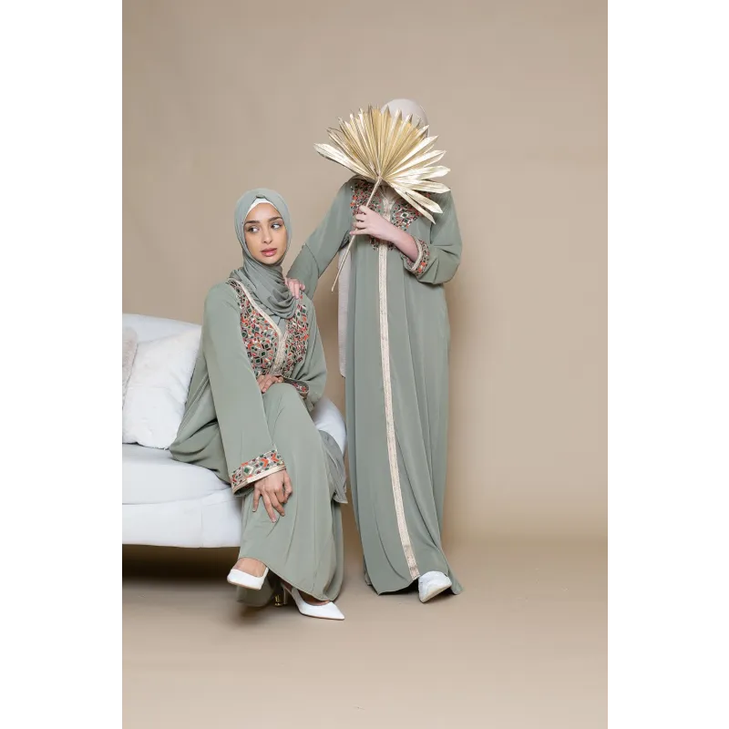 Sagegroene abaya met witte rand en bloemmotief, bijpassende hijab