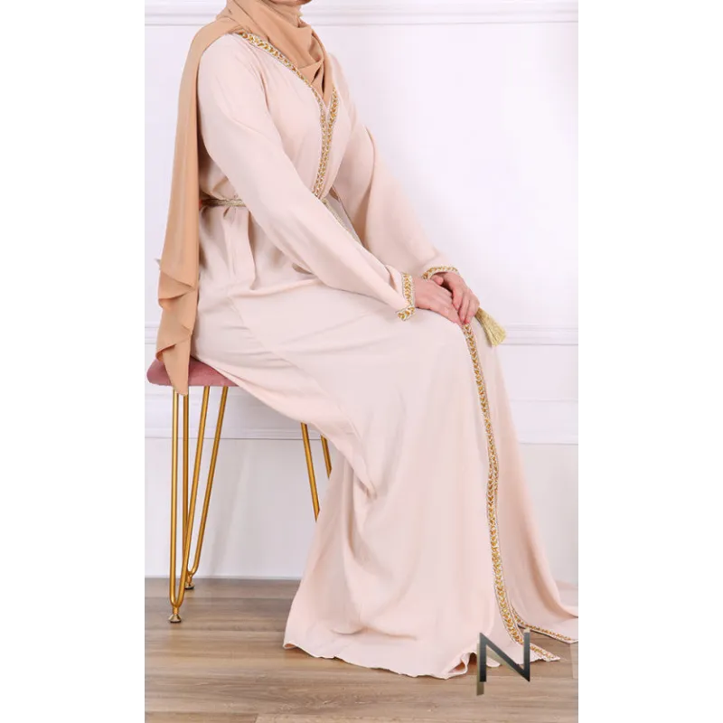 Mooi luxe kaftan Faouzia Binti: beige abaya met gouden details en hijab