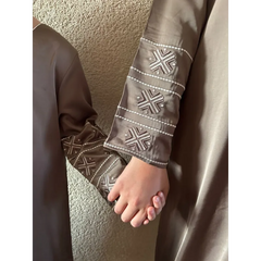 Bruine geborduurde abaya met witte kruispatronen en bijpassende manchetten van Kaftan Sara Binti