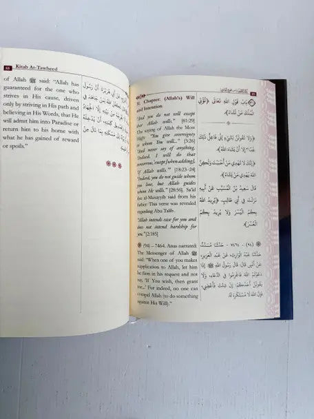 Open book of kitab at-tawheed by imam al-bukhari with bilingual arabic and english text and dark blue cover