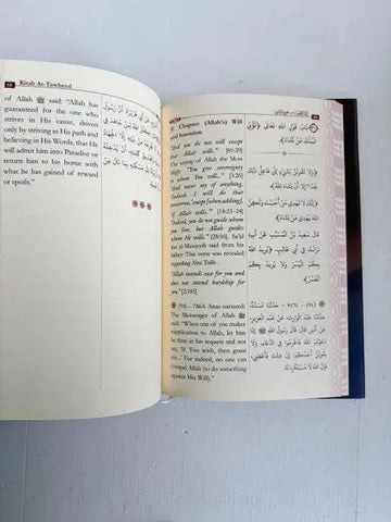 Open book of kitab at-tawheed by imam al-bukhari with bilingual arabic and english text and dark blue cover