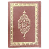 Een maroon leren gebonden koran met goud geëmbosseerde arabische kalligrafie en sierlijke randen in a5 formaat