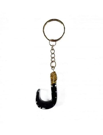 Zwarte resin sleutelhanger in de vorm van de letter j met een goudkleurige ingebedde edelsteen laam arabisch alfabet
