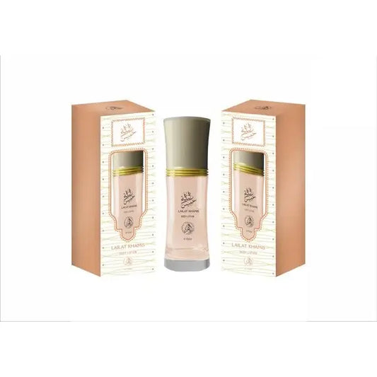 Een slanke doorzichtige glazen fles met bleekroze parfum en zilveren dop met gouden banden voor lailat khamis body lotion