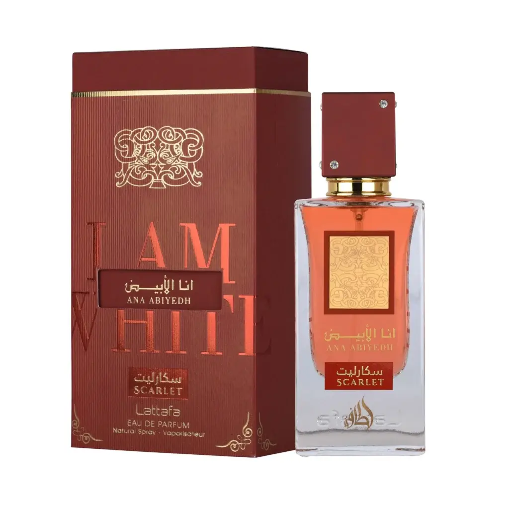 Een rechthoekige glazen parfumfles lattafa ana abiyedh scarlet edp 60ml met een bordeauxrode dop en gouden accenten gevuld met amberkleurige vloeistof