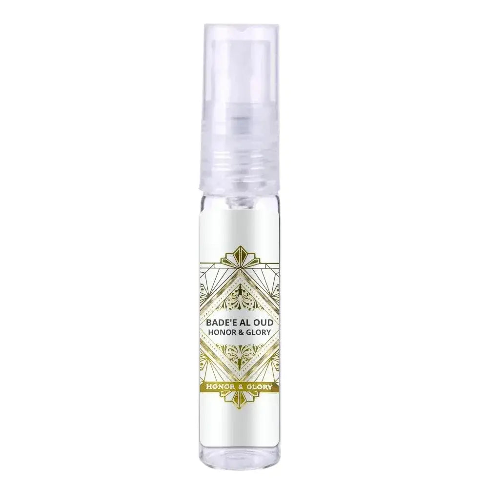Een heldere glazen sprayfles met een wit etiket en gouden geometrische en bloemmotieven van lattafa badee al oud honor & glory