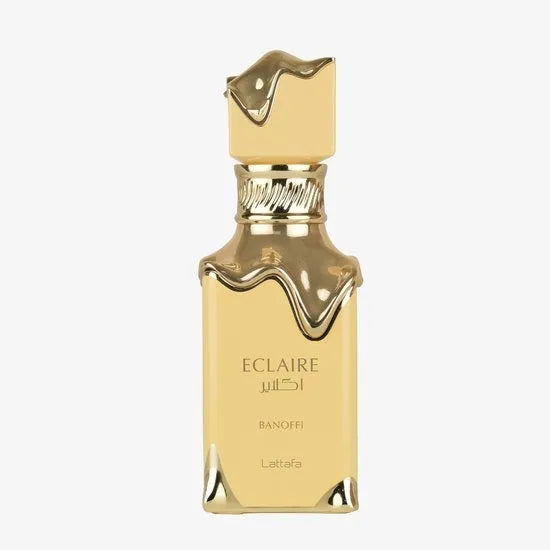 Gouden vierkante Lattafa Eclair Banoffi EDP 100 ml parfumfles met druipend gouden dop en basisaccenten