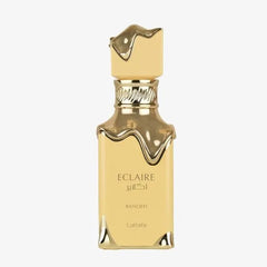 Gouden vierkante Lattafa Eclair Banoffi EDP 100 ml parfumfles met druipend gouden dop en basisaccenten