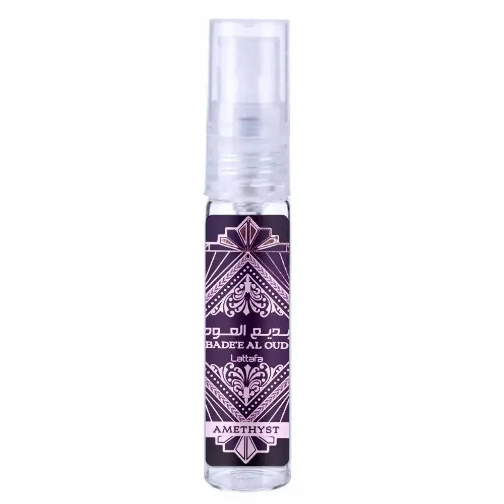 Een heldere glazen sprayfles van lattafa parfum badee oud amethyst met een paars-wit etiket in arabische stijl