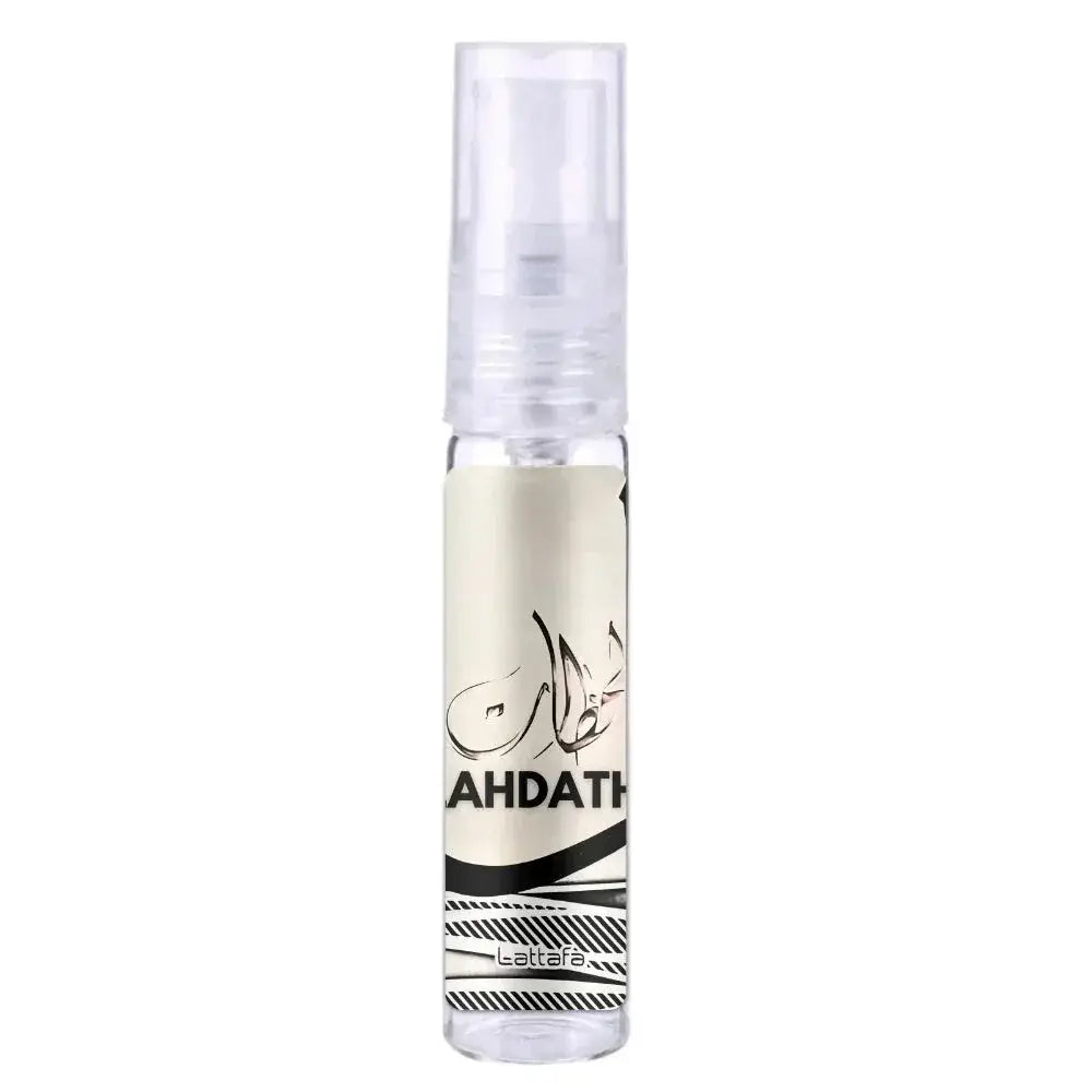 Een heldere glazen sprayfles met doorzichtige dop en crème label met zwarte arabische kalligrafie en Lattafa Parfum Lahdath branding