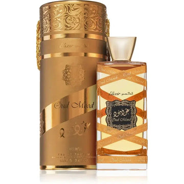 Gouden cilindrische parfumfles met gedetailleerde reliëfpatronen en bijpassende sierlijke doos met label oud mood van lattafa parfum oud mood elixir