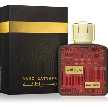 Rood glazen parfummfles met gouden dop en geperste tekst ramz lattafa naast zwarte doos van lattafa parfum ramz gold