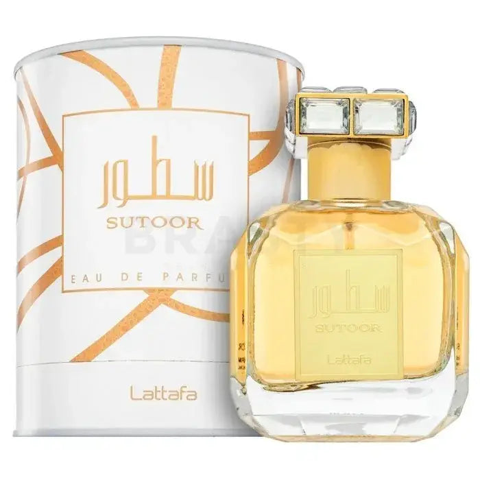 Een gouden gefacetteerde glazen parfumfles met een kristallen gouden dop en witte doos met oranje patronen van lattafa parfum sutoor