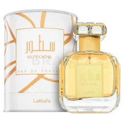 Een gouden gefacetteerde glazen parfumfles met een kristallen gouden dop en witte doos met oranje patronen van lattafa parfum sutoor