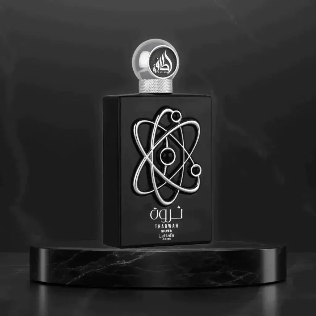Zwarte rechthoekige parfumfles met zilveren atoomsymbool en bolvormige dop met arabisch schrift labeled tharwah silver door lart de la parfumerie