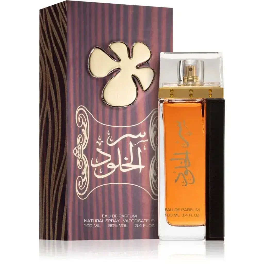 De lattafa ser al khulood eau de parfum met amberkleurige inhoud en goudkleurige spray naast paarse doos met arabische kalligrafie