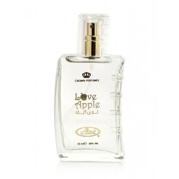 Clear glass bottle of crown perfumes love apple fragrance with a gold-tone spray nozzle and embossed arabic script on the label