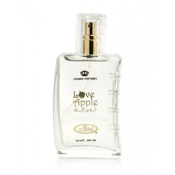 Clear glass bottle of crown perfumes love apple fragrance with a gold-tone spray nozzle and embossed arabic script on the label