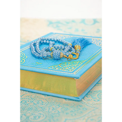 Prayer beads with blue tassels on a turquoise book in luxe blauwe cadeauset