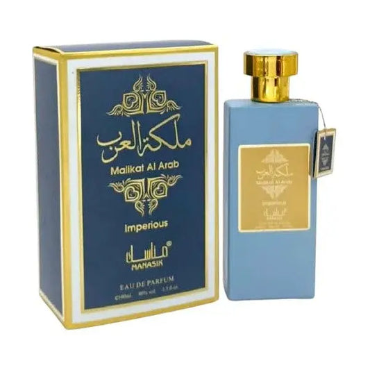 Lichte blauwe rechthoekige Manasik Malikat al Arab Imperious parfumfles met gouden dop naast navy blauwe doos met Arabisch schrift