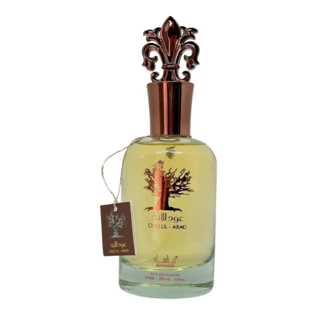 Een heldere glazen fles met oud lil-abao eau de parfum door maaask met een roségouden kap en boomreliëf, manasik oud al araqa