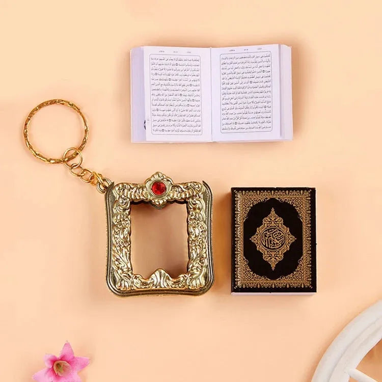 Decoratieve gouden sleutelhanger met rode edelsteen en Mini Koran Luxe boeken