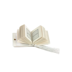 Open boek met ruffled pagina’s en een bookmark van Mini Koran met Kaaba deur patroon