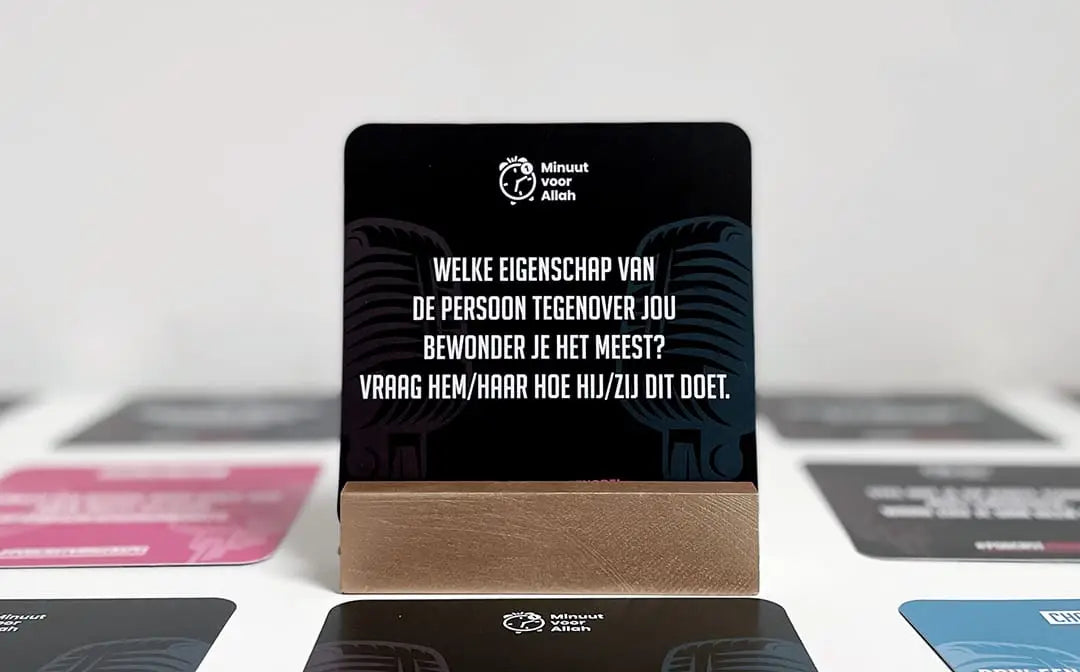 Minuut voor allah podcast het spel toont een zwarte rechthoekige kaart met witte tekst en microfoongrafiek op houten standaard