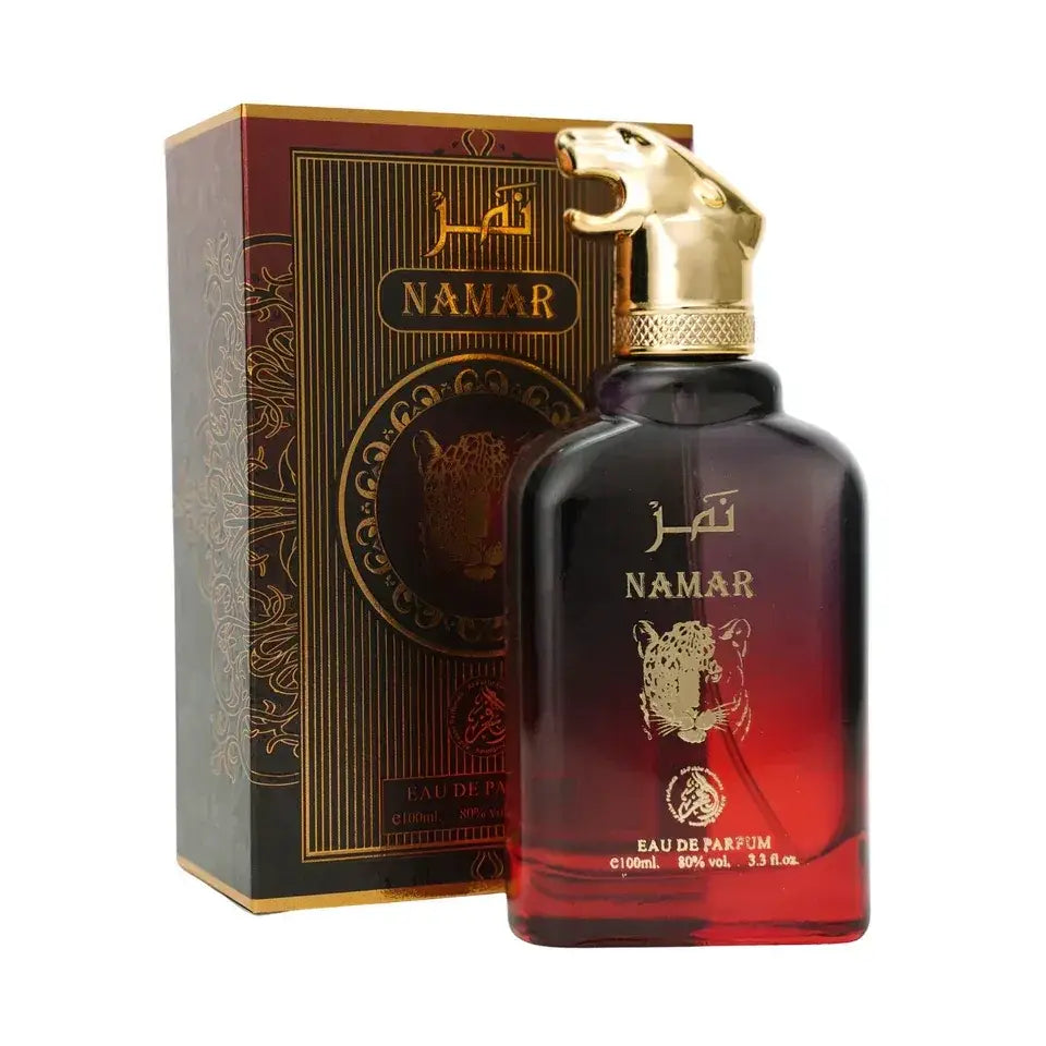 Een elegante donkerrode tot amberkleurige glazen fles namar eau de parfum met een gouden tijgerkopdop en reliëf gouden tijgerdesign