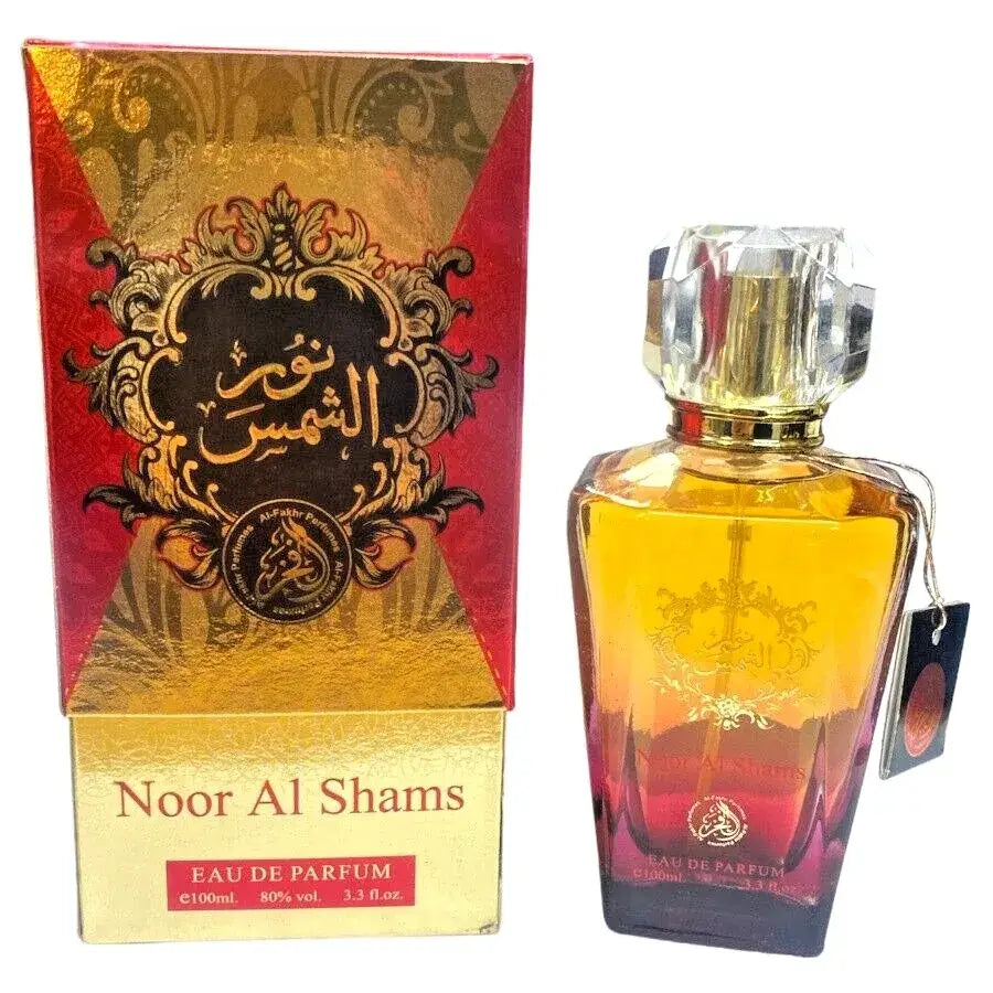 Gouden en rode gradient glazen parfumfles met facet geslepen kristallen dop labeled noor al shams eau de parfum