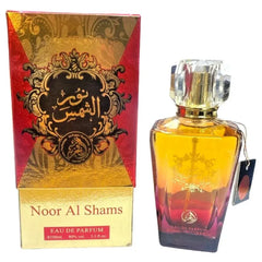 Gouden en rode gradient glazen parfumfles met facet geslepen kristallen dop labeled noor al shams eau de parfum