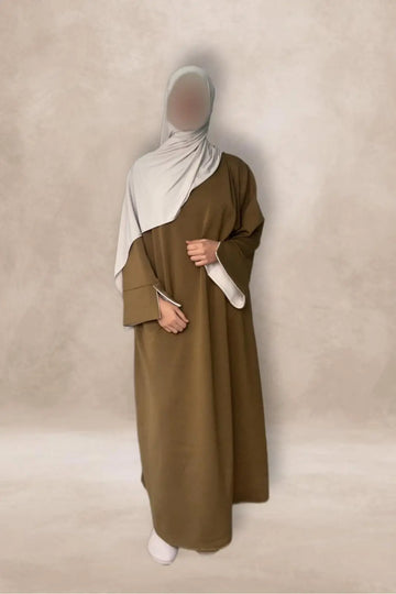 Een oversized olive groene abaya met witte biezen op de mouwen en een lichtgrijze hijab in one size