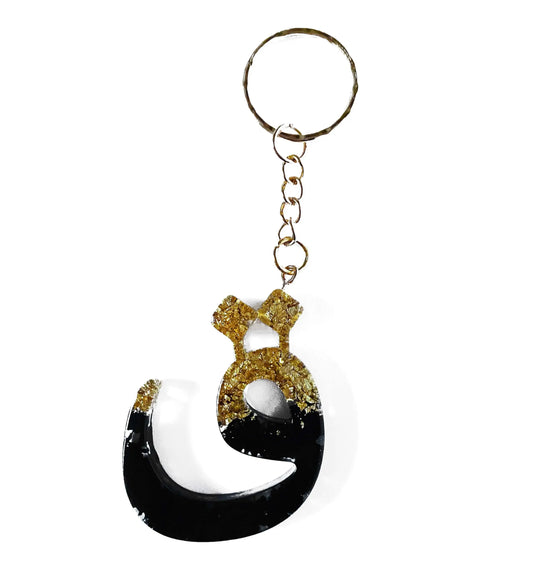 Zwart en goudkleurige resin sleutelhanger in de vorm van de arabische letter ج met metalen ring en ketting