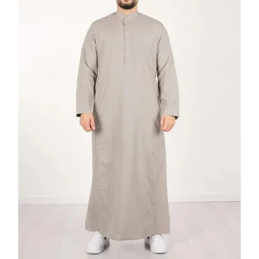 Een man draagt een lichtgrijze qamis ind24 q4him met lange mouwen, knoopsluiting en mandarijnkraag