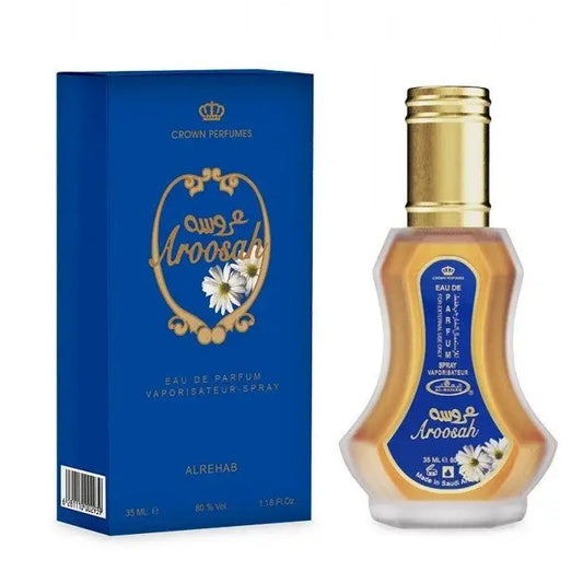 Een gouden glazen parfumfles met gouden dop en blauwe label met witte madeliefjes van alrehab crown perfumes aroosah