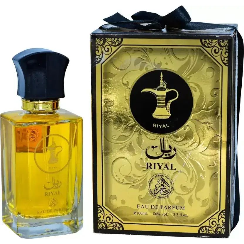 Goudengele riyal edp parfumfles met zwarte dop en gouden accenten naast een gouden doos met arabische kalligrafie en koffiepotlogo