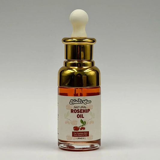 Een slanke transparante glazen fles met gouden druppelaar en amberkleurige biologische rozenbottelolie 45ml