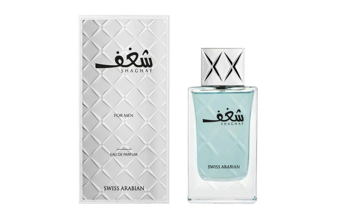 Een slanke doorzichtige glazen fles shagaf swiss arabian eau de parfum voor mannen met zilveren dop en lichtblauwe vloeistof