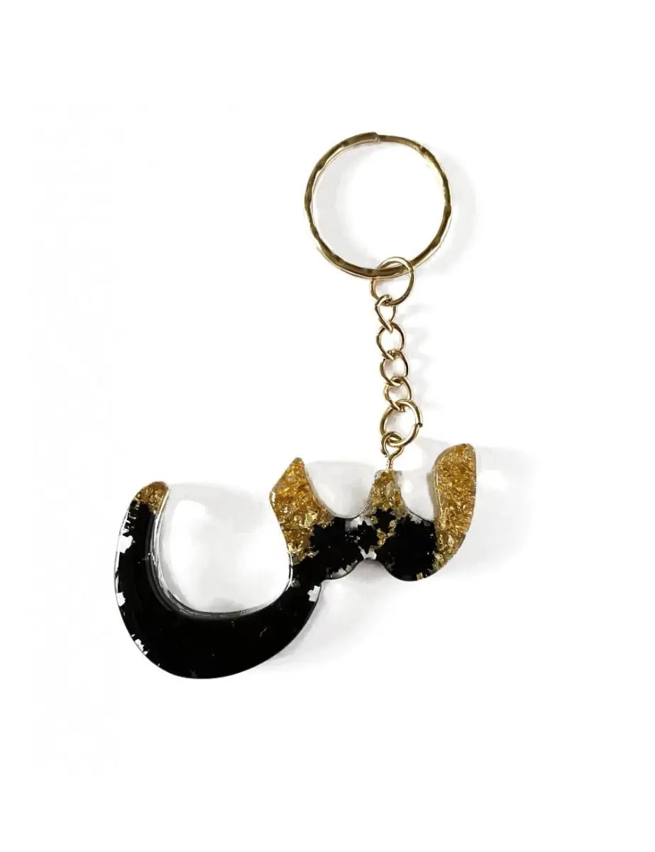 Zwarte en gouden hars sleutelhanger in de vorm van de arabische letter ج met metalen ring en ketting, sien - arabisch alfabet sleutelhanger