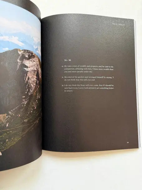 Open boek surah al-kahf met zwarte pagina en witte tekst naast foto van rotsachtig berglandschap
