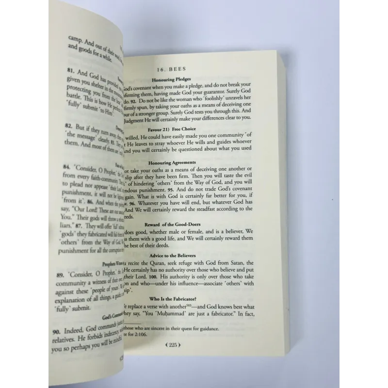 Open boek De Clear Quran, vergeelde pagina’s met zwarte tekst