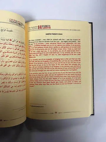 Open book from the explanation of imam al-nawawis 40 hadith 2 volume set with arabic and english text in red on cream pages