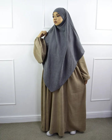 Een zachte grijze hijab met een vloeiend ontwerp gedragen over een lange beige jurk in de velvet papillon abaya collectie
