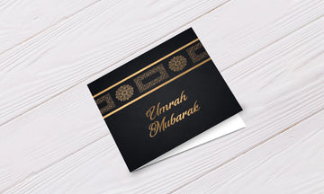 Zwarte wenskaart umrah mubarak met goudfolie tekst en sierlijke gouden randen voor speciale gelegenheden
