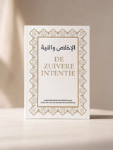 Een wit hardcover boek de zuivere intentie met goudgegoten arabische en nederlandse tekst en een gouden geometrische rand